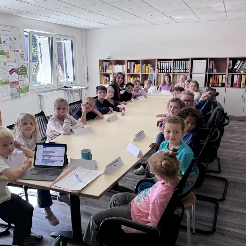 Kinderparlament der Grundschule Lotte sitzt gemeinsam am Besprechungstisch.