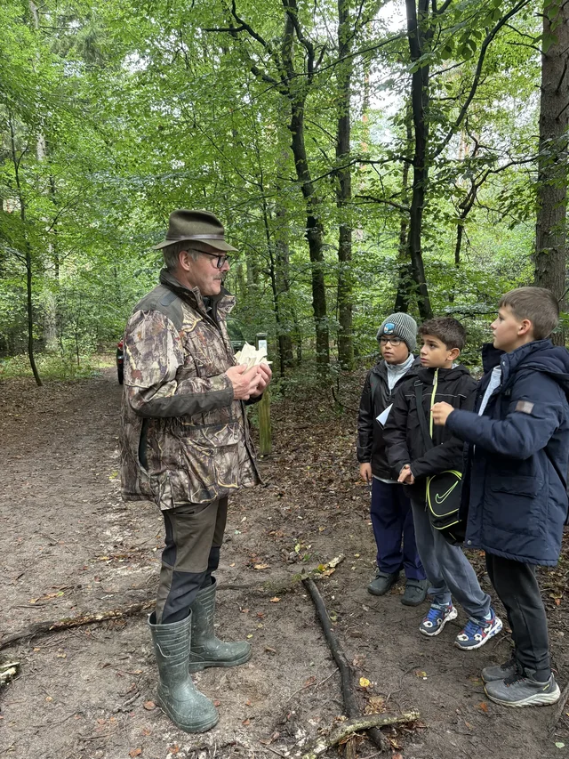 Fachperson spricht mit einer Schülergruppe im Wersener Holz.