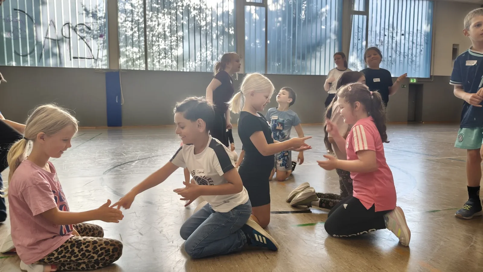 Kinder arbeiten in der Sporthalle bei einer Teambuilding-Übung zusammen.
